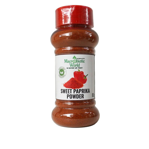 Bottle of sweet paprika powder with a red lid on a gray background