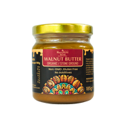 Jar of walnut butter with a gold lid on a white background